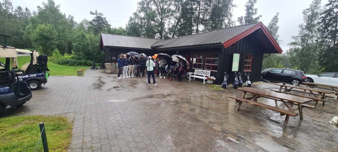 Paraply: De fleste hadde kledd seg noenlunde etter været - her ved Asker Golfklubbs pro shop hvor Marie Høgmoen gikk gjennom spilleregler og lag.